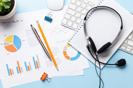 Office desk with headset and supplies. Remote office and work from home concept. Top veiw flat lay