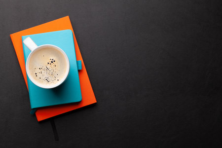 Office desk with supplies and coffee cup over black leather table. Top view flat lay with copy spaceの写真素材