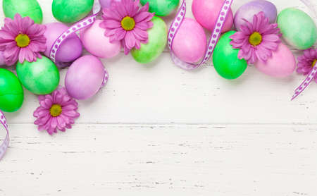 Easter greeting card with colorful easter eggs and flowers. Top view flat lay with space for your...