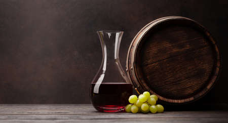 Wine decanter, grapes and old wooden barrel. With copy spaceの写真素材
