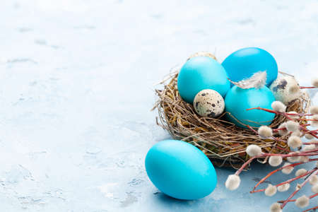 Colorful easter eggs in nest on stone background. With space for your greetingsの写真素材
