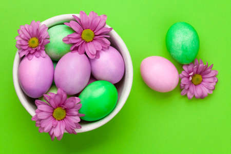 Easter greeting card with colorful easter eggs and flowers. Top view flat lay