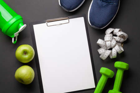 Fruits, dumbbells and blank sheet for your plan or goals. Sport, fitness and healthy lifestyle background. Top view flat lay with copy spaceの写真素材