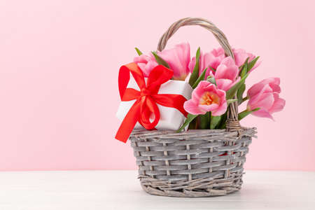 Pink tulip flowers bouquet and gift boxes in front of pink background. With copy spaceの写真素材