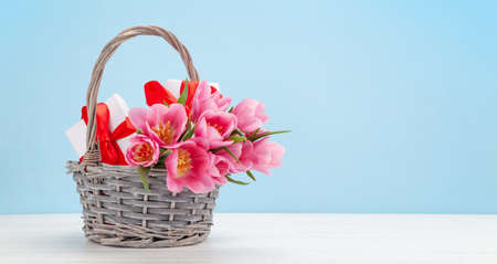 Pink tulip flowers bouquet and gift boxes in front of blue background. With copy spaceの写真素材