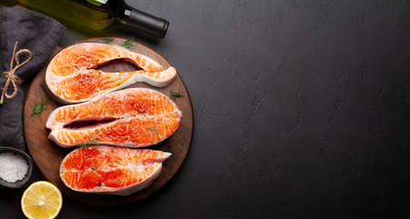 Fresh raw salmon cooking. Fish steaks with herbs, spices and white wine. Top view flat lay with copy spaceの写真素材