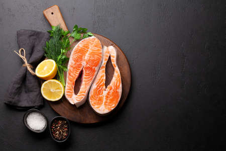 Fresh raw salmon cooking. Fish steaks with herbs and spices. Top view flat lay with copy spaceの写真素材