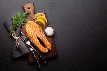 Grilled salmon steak. Fish steak with herbs and spices. Top view flat lay with copy spaceの写真素材