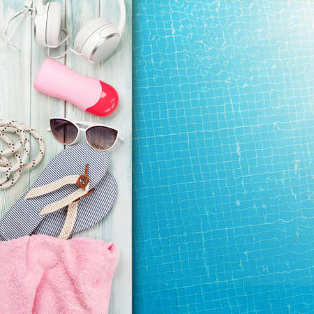 Pool and beach items and water surface of swimming pool. Travel and vacation concept. Top view flat lay with copy spaceの写真素材