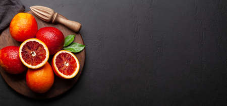 Fresh citrus fruits. Bood oranges and juicer. Top view flat lay with copy spaceの写真素材