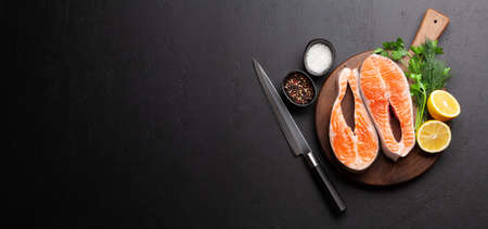 Fresh raw salmon cooking. Fish steaks with herbs and spices. Top view flat lay with copy spaceの写真素材