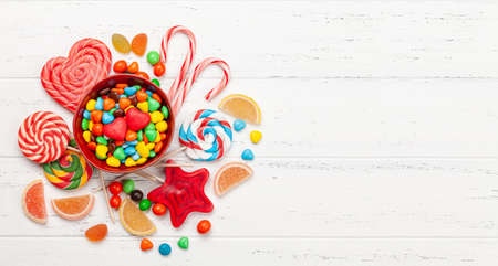 Various sweets assortment. Candy, bonbon and marmalade on wooden background. Top view flat lay with copy spaceの写真素材