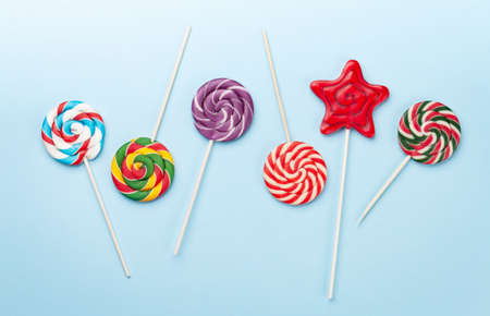 Various sweets assortment. Candy lollipops over blue background. Top view flat layの写真素材