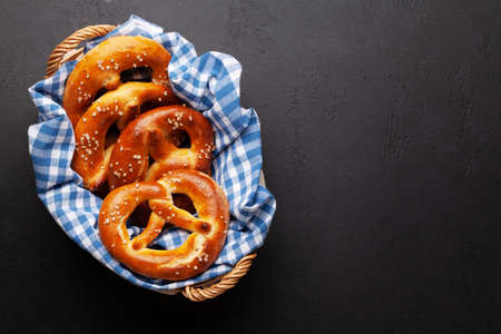 Fresh baked homemade pretzel with sea salt on stone table. Classic beer snack. Top view flat lay with copy spaceの写真素材