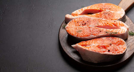 Fresh raw salmon cooking. Fish steaks with herbs and spices. With copy space