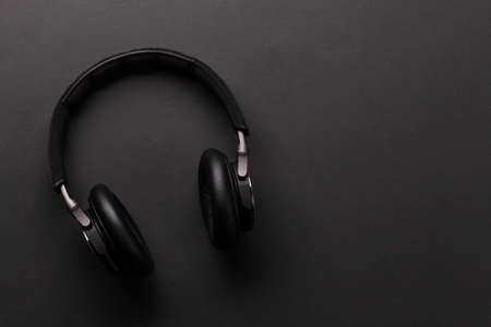 Wireless headphones on dark background. Top view flat lay with copy space
