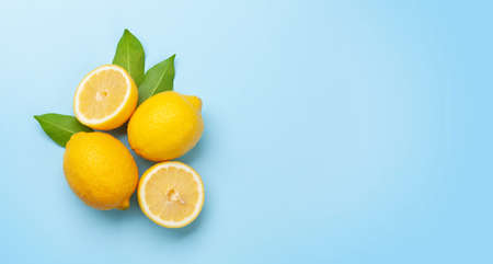 Fresh ripe lemons on blue background. Top view flat lay with copy spaceの写真素材