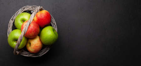 Fresh ripe apples in basket on stone background. Red and green apple fruits. Top view flat lay with...