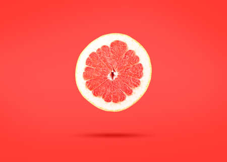 Slice of grapefruit citrus over pink backgroundの写真素材