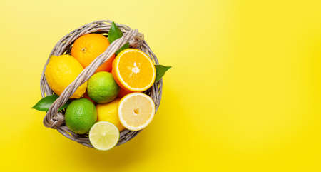 Fresh ripe citrus fruits on yellow background. Orange, lemon, lime. Top view flat lay with copy spaceの写真素材