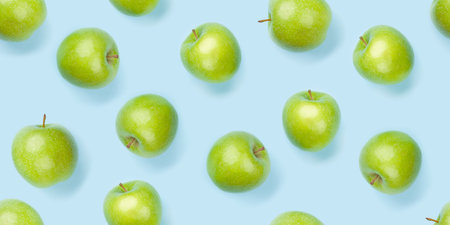 Green apple fruits over blue seamless backdrop texture. Flat lay backgroundの写真素材