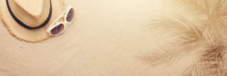 Travel vacation background concept with sunglasses and beach hat on sand backdrop. Top view with copy space. Flat layの写真素材