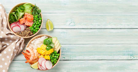 Poke bowls with shrimps, salmon, avocado and mango. Traditional hawaiian meal. Top view flat lay...