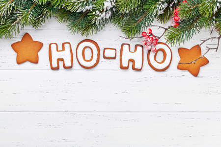 Christmas greeting card with homemade gingerbread HO-HO text and fir tree. Top view flat lay with space for your greetingsの写真素材
