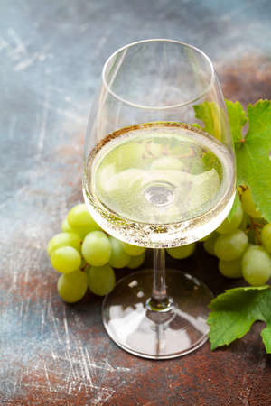 White wine glass and grape on old stone tableの写真素材