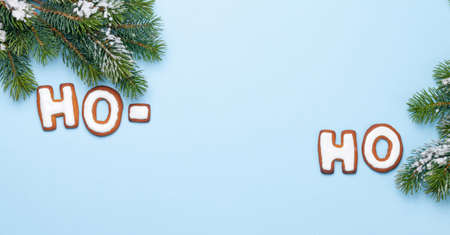 Christmas greeting card with homemade gingerbread HO-HO text and fir tree. Top view flat lay with space for your greetingsの写真素材