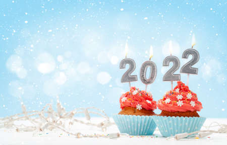 Christmas greeting card with cupcakes, 2022 candles and garlands. With space for your xmas greetings