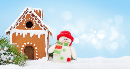 Christmas greeting card with gingerbread house, fir tree and snowman toy. With copy space for your...