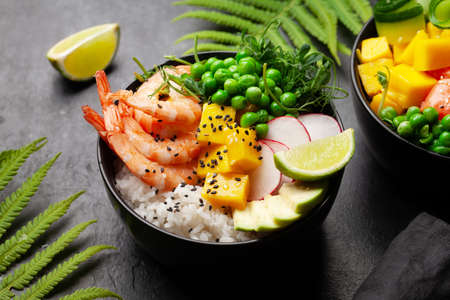 Poke bowls with shrimps, salmon, avocado and mango. Traditional hawaiian mealの写真素材