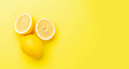 Fresh ripe lemons on yellow background. Top view flat lay with copy spaceの写真素材