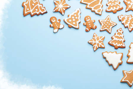Christmas card with gingerbread cookies over blue background. Top view flat lay with space for xmas...