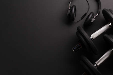 Headphones and dumbbells. Sport, fitness and healthy lifestyle background. Top view flat lay with copy spaceの写真素材