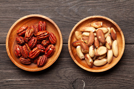 Various nuts in bowls on a wooden table. Top view flat lay
