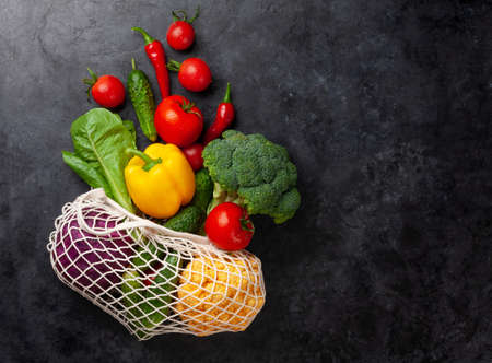 Eco friendly mesh shopping bag with fresh vegetables. Top view flat lay with copy spaceの写真素材