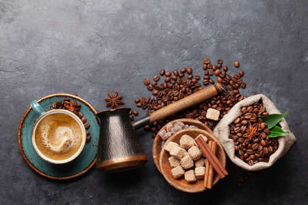 Roasted coffee beans, Turkish jezve, espresso coffee cup and brown sugar. Top view flat lay with copy spaceの写真素材