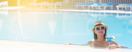 Woman relaxing at the swimming pool with tropical cocktail. With copy spaceの写真素材
