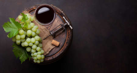 Red wine glass and white grape on old wooden barrel. Top view flat lay with copy spaceの写真素材