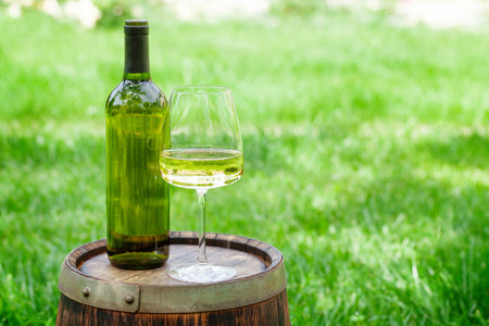 Wine bottle and glass with white wine on old barrel. With copy spaceの写真素材