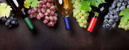 Wine bottles and grapes on stone table. Top view flat layの写真素材