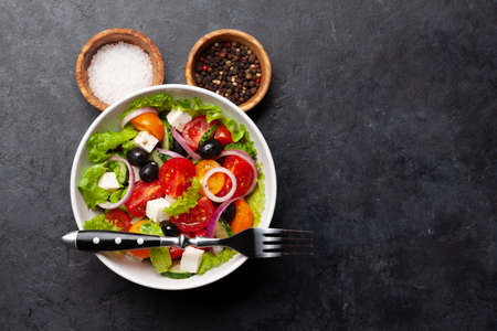Classic greek salad with fresh garden vegetables. Top view flat lay with copy spaceの写真素材
