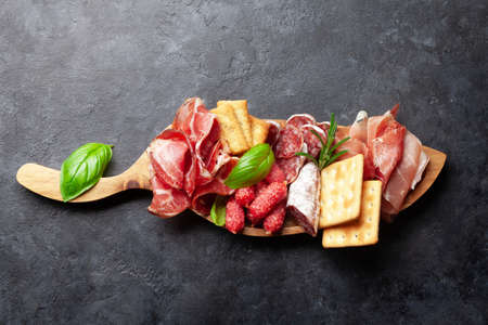Antipasto board with prosciutto, salami and crackers. Top view flat lay with copy spaceの写真素材