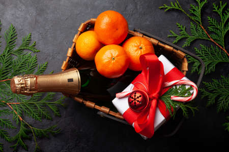 Christmas gift basket with champagne bottle, decor, gift boxes and fruits. Top view flat layの写真素材