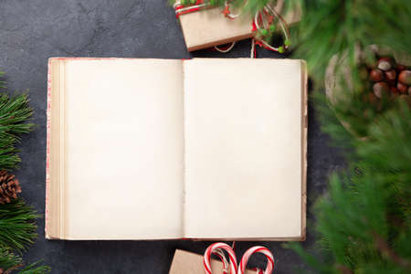 Christmas gift box with craft decor and vintage book. Top view flat lay with space for your greetingsの写真素材