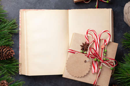 Christmas gift box with craft decor and vintage book. Top view flat lay with space for your greetingsの写真素材