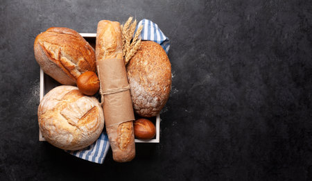 Various types of bread on stone table. Top view flat lay with copy space