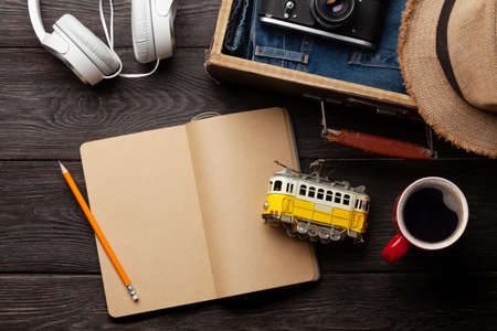 Travel and vacation concept. Trip accessories and items. Coffee cup, blank notepad and tram toy. Top...